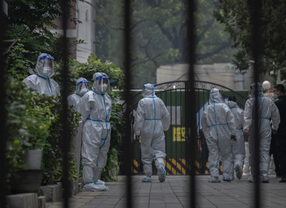  Health workers and security wearing protective clothing work inside a compound under lockdown after new COVID-19 cases were found in the area on June 16, 2022 in Beijing, China