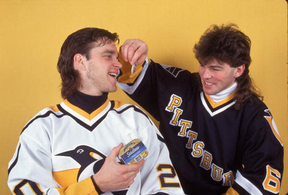 Czech professional hockey player Jaromir Jagr of the Pittsburgh Penguins pretends to feed sardines to his teammate Canadian Luc Robitaille, February 1995. (Photo by Bruce Bennett Studios/Getty Images)