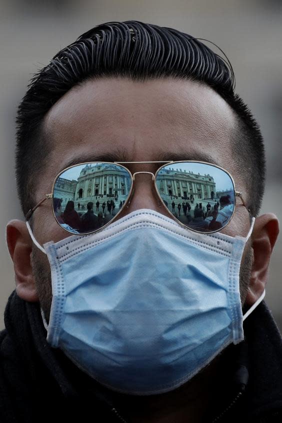 A man wears a mask in St Peter’s Square during Pope Francis’s weekly audience on Wednesday (AP)