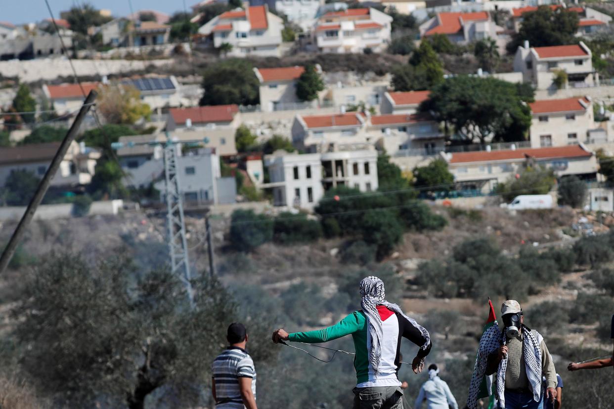 Palestinian demonstrators stand in front of a Jewish settlement during a protest in the Israeli-occupied West Bank (REUTERS)