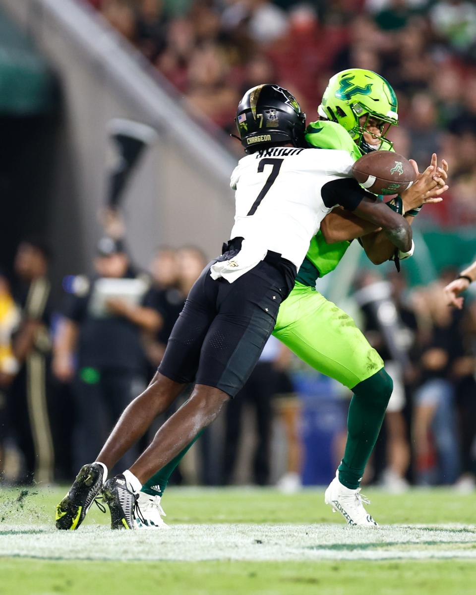 Nov 26, 2022; Tampa, Florida, USA; UCF Knights cornerback Davonte Brown (7) causes a fumble after hitting South Florida Bulls quarterback Byrum Brown (17) during the third quarter at Raymond James Stadium. Mandatory Credit: Douglas DeFelice-USA TODAY Sports