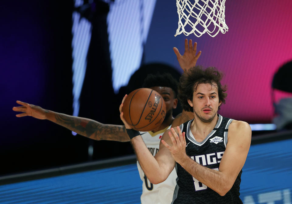 Sacramento Kings' Nemanja Bjelica, right, handles the ball against the New Orleans Pelicans during the first half of an NBA basketball game Tuesday, Aug. 11, 2020, in Lake Buena Vista, Fla. (Mike Ehrmann/Pool Photo via AP)