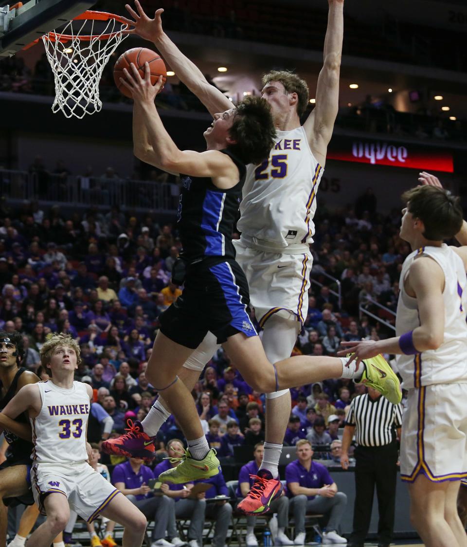 Waukee Northwest guard Grant Tigges (25) takes a shot around Waukee forward Vance Peiffer (25) during the first quarter in the class 4A boys state basketball semifinal at Wells Fargo Arena Thursday.