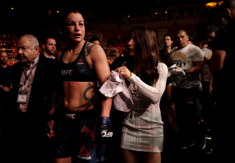 Raquel Pennington leaves the cage with her fiancee Tecia Torres . (REUTERS/Ricardo Moraes)