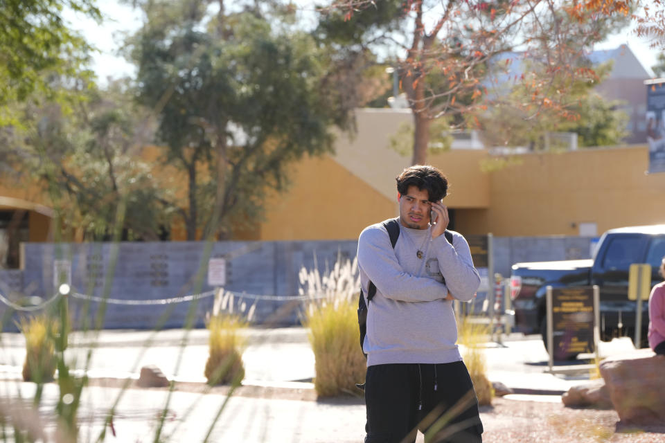 A University of Nevada, Las Vegas, student talks on his cellphone after a shooting reported on campus, Wednesday, Dec. 6, 2023, in Las Vegas. (AP Photo/Lucas Peltier)