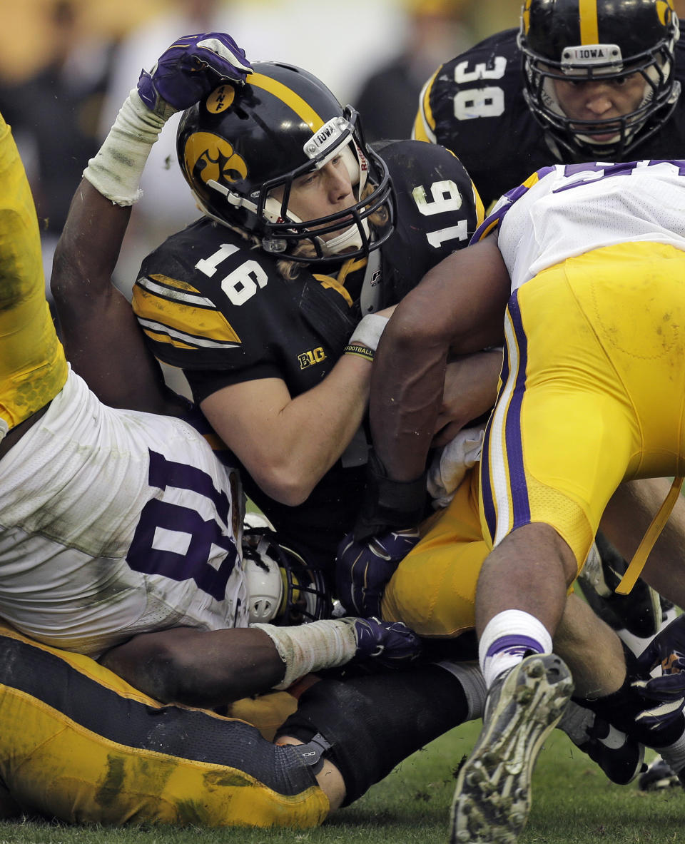 Iowa quarterback C.J. Beathard (16) is stopped by LSU defensive end Danielle Hunter, right, and linebacker Lamin Barrow (18) during the fourth quarter of the Outback Bowl NCAA college football game Wednesday, Jan. 1, 2014, in Tampa, Fla. LSU won the game 21-14. (AP Photo/Chris O'Meara)
