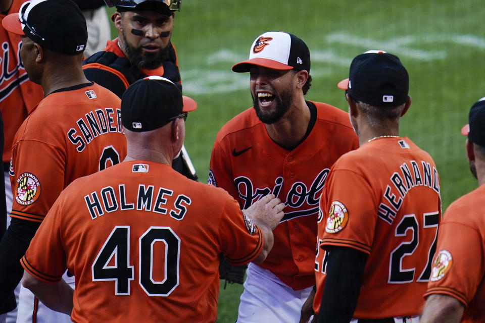 Baltimore Orioles relief pitcher Jorge Lopez, center, reacts with assistant pitching coach Darren Holmes (40) after recording the save against the Cleveland Guardians during a baseball game, Saturday, June 4, 2022, in Baltimore. The Orioles won 5-4. (AP Photo/Julio Cortez)