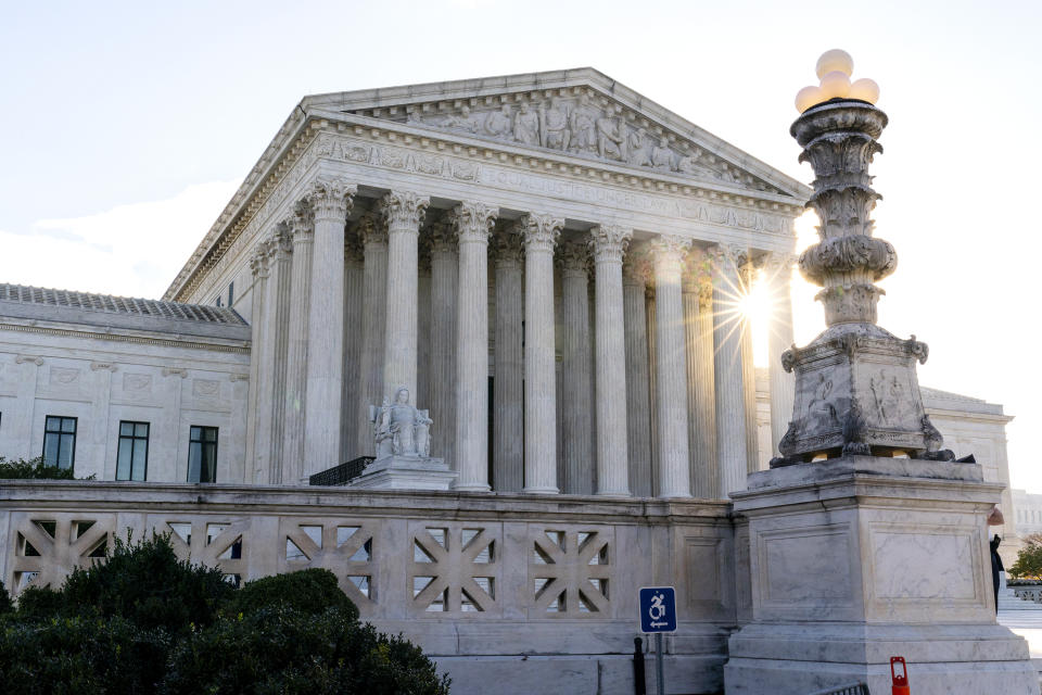 FILE - The sun rises behind the U.S. Supreme Court in Washington, on Nov. 10, 2020. The federal government is warning law enforcement agencies around the nation of the increased potential for extremist violence following the leak of a draft Supreme Court opinion striking down the constitutional right to abortion. (AP Photo/Alex Brandon, File)