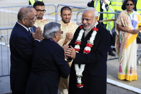 Prime Minister Narendra Modi is presented with a garland of blossoms after arriving at Heathrow Airport for a three day official visit, in London, November 12, 2015. REUTERS/Jonathan Brady/Pool