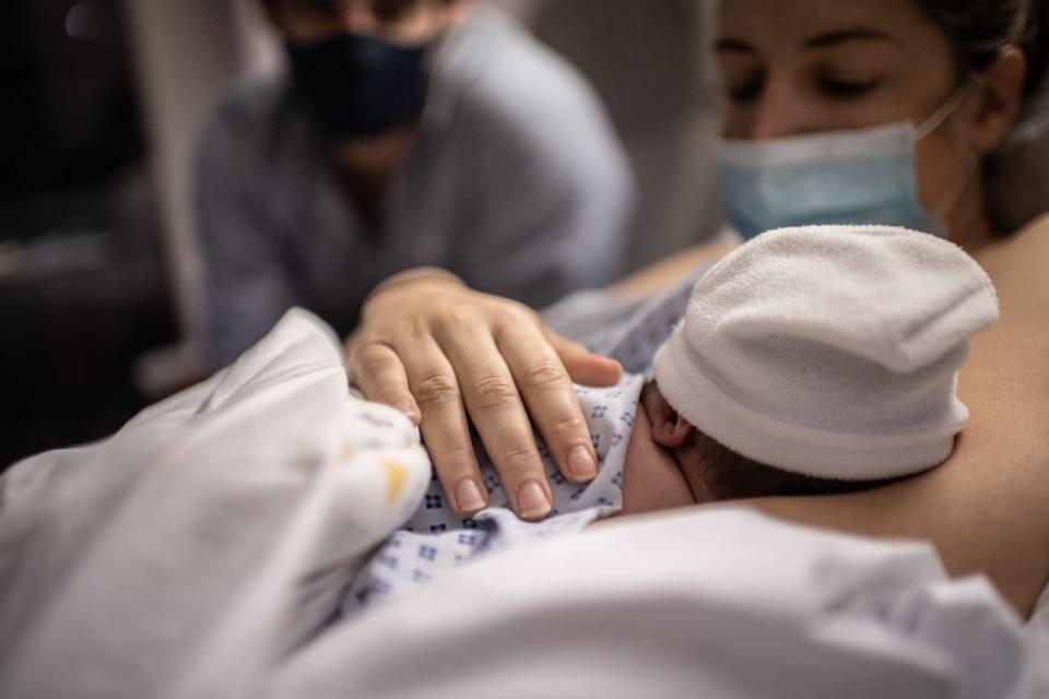 A father and a mother look at their newborn son during the Covid-19 pandemic, novel coronavirus at the maternity of the Diaconesses hospital in Paris, on November 17, 2020. (Photo by Martin BUREAU / AFP) (Photo by MARTIN BUREAU/AFP via Getty Images)