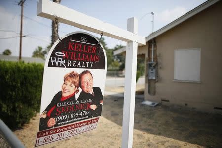 A real estate sign is seen outside a deserted home stripped of its copper wiring in San Bernardino, California September 11, 2012. REUTERS/Lucy Nicholson