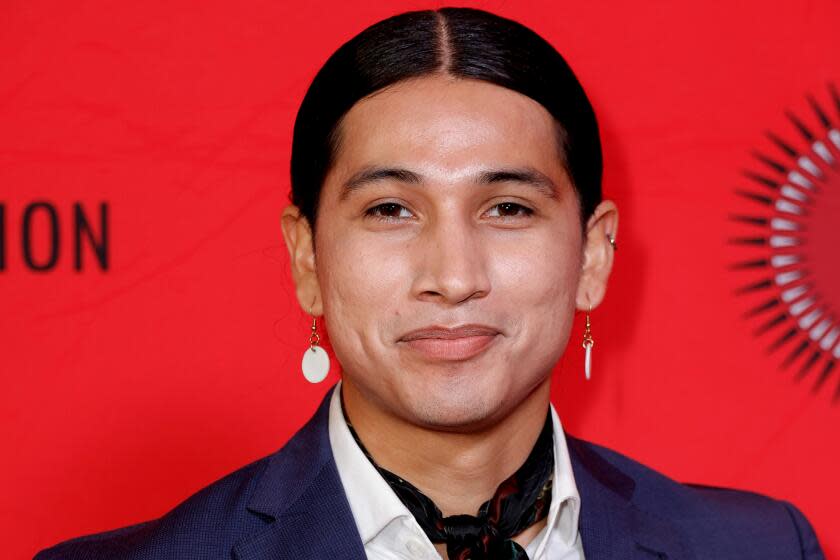 Cole Brings Plenty in blue suit and white dangling earrings on red carpet