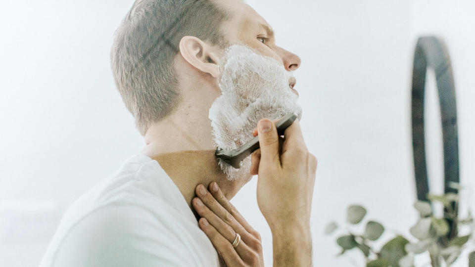 man shaving in bathroom