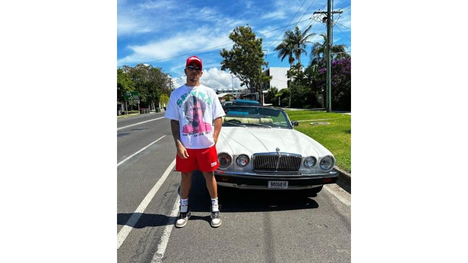 Lewis Hamilton stood in front of a classic car