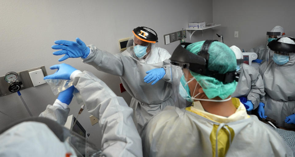 Dr. Joseph Varon, center, reaches for an IV bag inside the Coronavirus Unit at United Memorial Medical Center, Monday, July 6, 2020, in Houston. Varon says he has worked more than 100 days with barely a rest and normally sleeps just a few hours a night. (AP Photo/David J. Phillip)