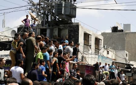 Palestinians watch as Hamas militants execute Palestinians suspected of collaborating with Israel in Gaza City August 22, 2014. REUTERS/Stringer