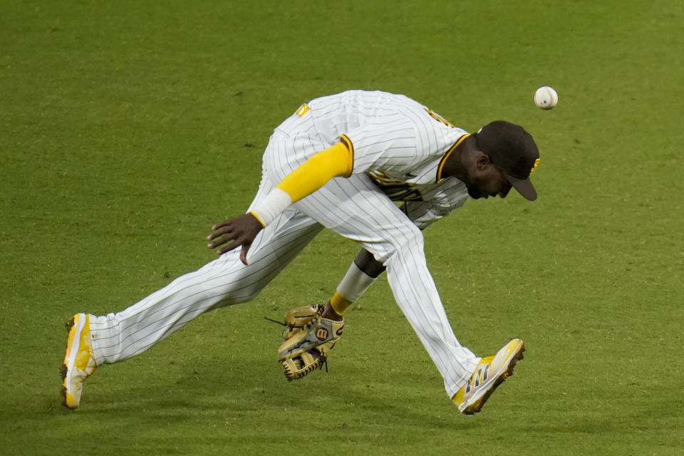 San Diego Padres second baseman Jurickson Profar can't field a ground ball hit for a single by Milwaukee Brewers' Corbin Burnes during the third inning of a baseball game Tuesday, April 20, 2021, in San Diego. (AP Photo/Gregory Bull)