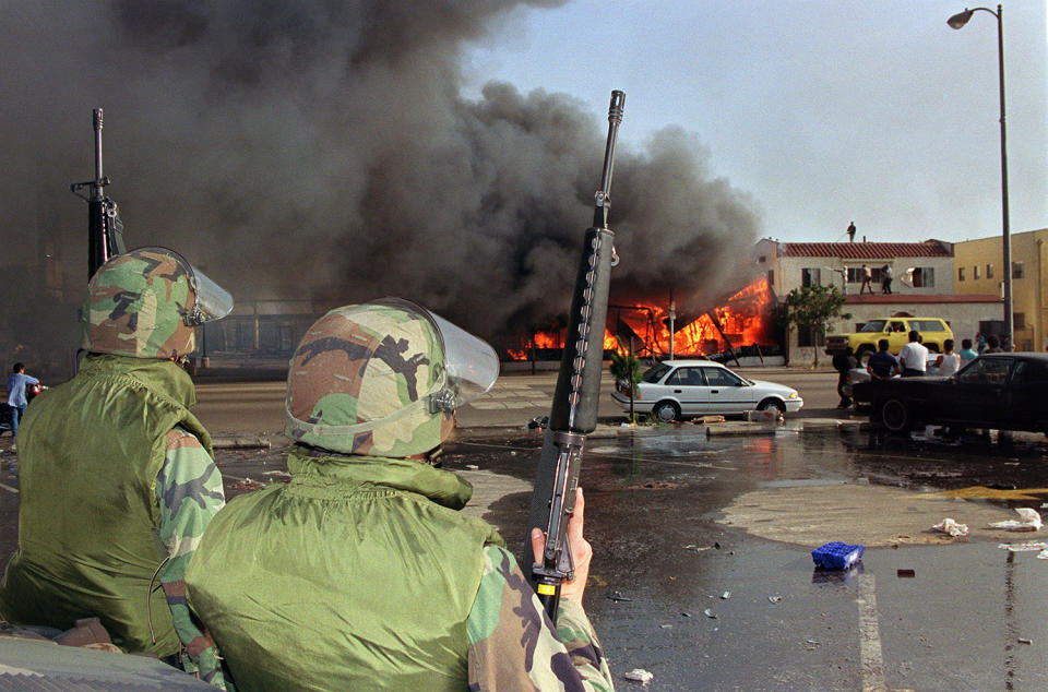 National Guardsmen watch burning building