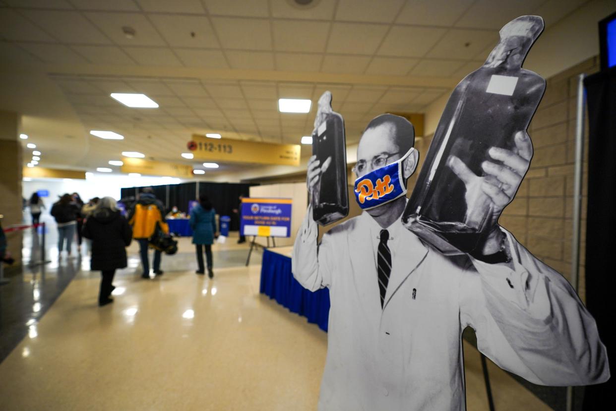 A cardboard standup of Dr. Jonas Salk, who, while a researcher at the University of Pittsburgh, developed one of the first successful Polio vaccines in 1955, stands in the Petersen Events Center on the Pitt campus during a COVID-19 vaccination clinic hosted by the University of Pittsburgh and the Allegheny County Health Department in Pittsburgh, Thursday, Jan. 28, 2021. 