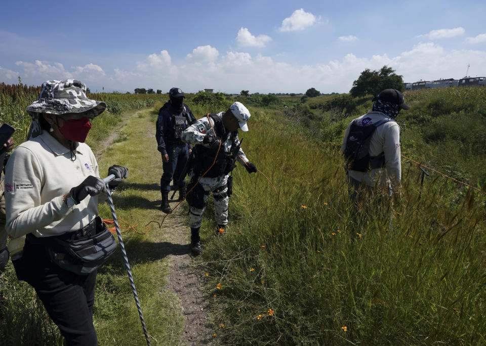 National Guards and volunteers search for disappeared persons on the outskirts of Cuautla, Mexico, Tuesday, Oct. 12, 2021. The government's registry of Mexico’s missing has grown more than 20% in the past year and now approaches 100,000. (AP Photo/Fernando Llano)
