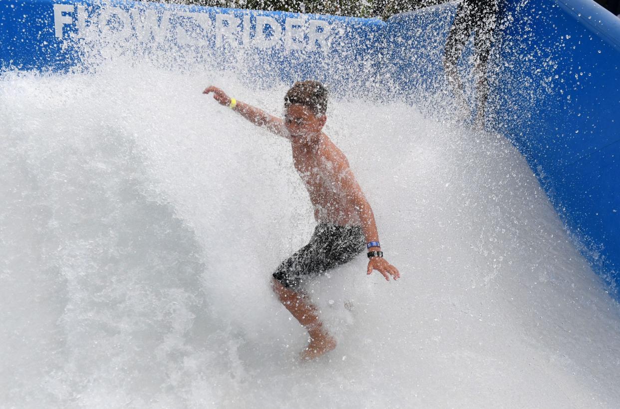 Remy Eiser, 11, tries the Flow-Rider water ride, one of the attractions for visitors as the X Games are held at the Ventura County Fairgrounds on Saturday.