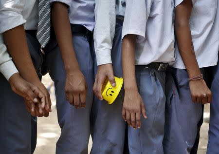 A student holds his tiffin box while standing in a queue to receive free mid-day meal being distributed by municipal workers at a government school in New Delhi, India, May 6, 2015. REUTERS/Anindito Mukherjee