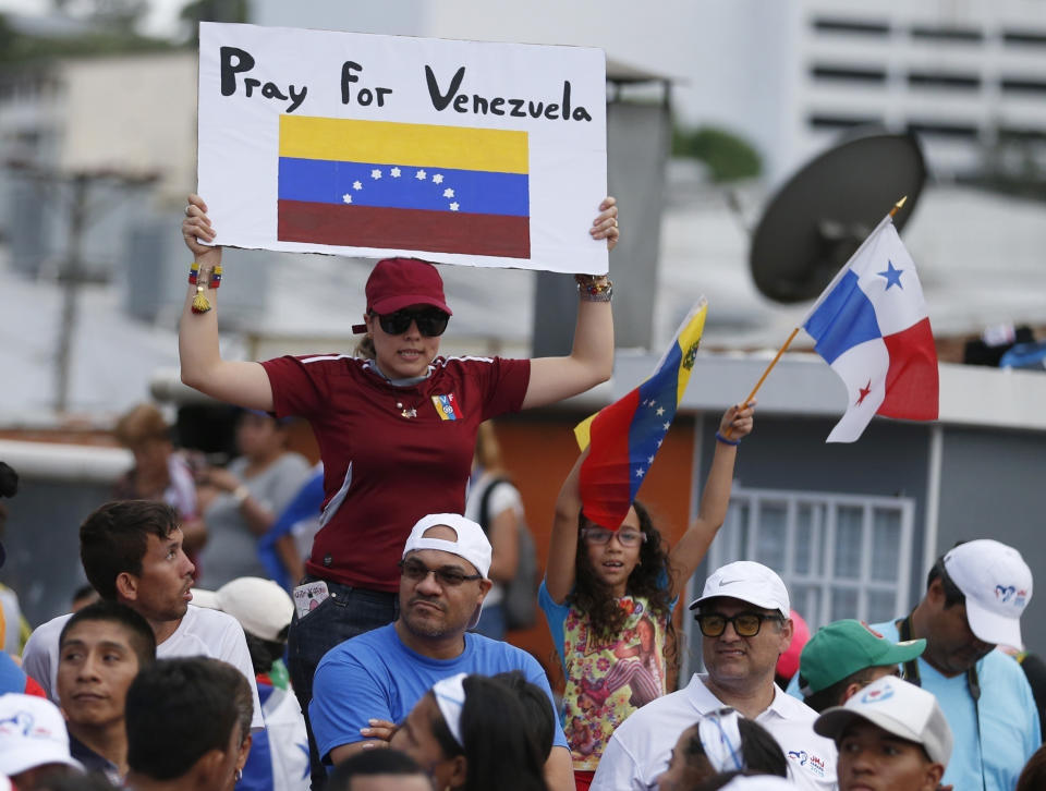 A person holds a "Pray for Venezuela sign" as Pope Francis rides the pope mobile through the streets of Panama City, Panama, Wednesday, Jan, 23, 2019. Pope Francis is in Panama to attend World Youth Day, the church's once-every-three-year pep rally that aims to invigorate the next generation of Catholics in their faith. (AP Photo/Rebecca Blackwell)