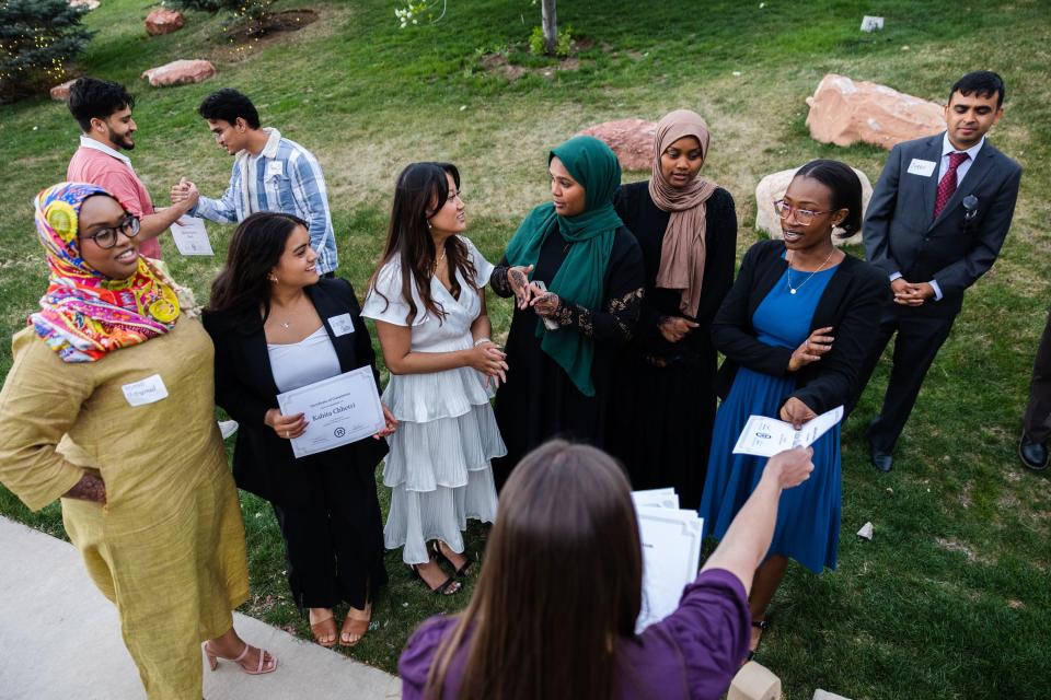 Graduates accept certificates of graduation from director of Elizabeth Zenger during the One Refugee graduation celebration at the Garden Place at Heritage Park in Salt Lake City on May 8, 2023. | Ryan Sun, Deseret News