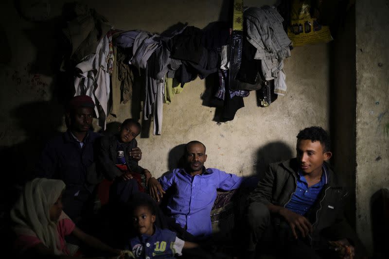 Hassan sits with his family inside their shelter in Sanaa