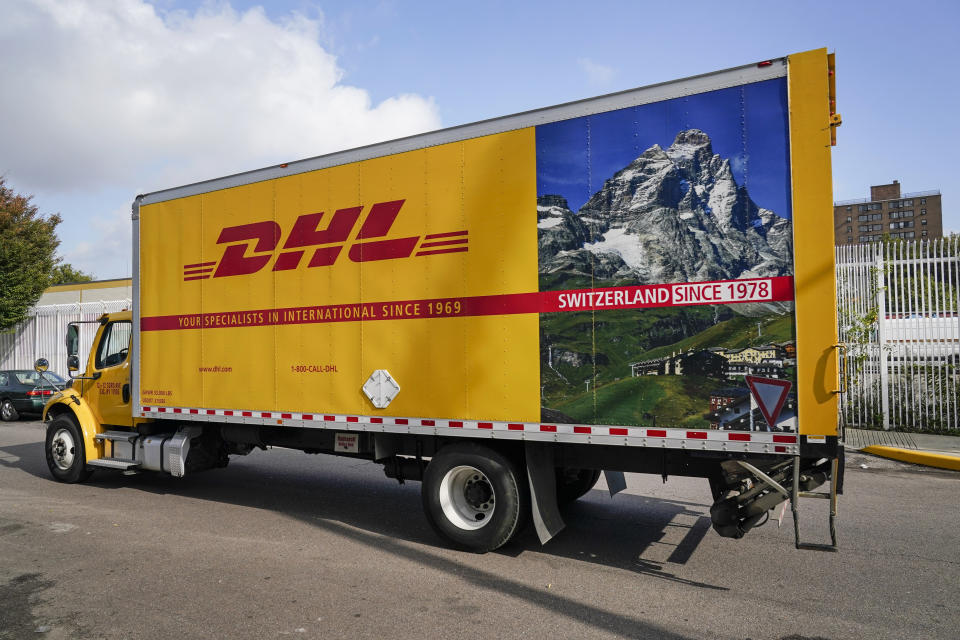 A DHL delivery truck passes a DHL location Tuesday, Oct. 20, 2020, in New York. DHL' eCommerce Solutions, a division that specializes in small packages for mid-size shippers, is hiring 900 more permanent workers to its current labor force of 3,000. It also will hire 1,400 temporary workers. (AP Photo/Frank Franklin II)
