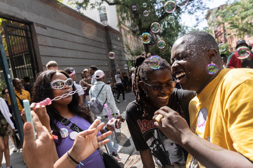 Maya Smith, left, blows bubbles during the Queer Juneteenth Block Party, sponsored by The Center, Sunday, June 18, 2023, in New York. 