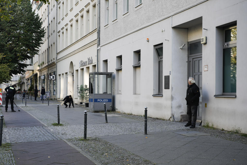 German police officers search in front of the building complex of the Kahal Adass Jisroel community, which houses a synagogue, a kindergarten and a community center, in the center of Berlin, Germany, Wednesday, Oct. 18, 2023. The Kahal Adass Jisroel community said its synagogue in the city's Mitte neighborhood was attacked with two incendiary devices. Police confirmed the incident.(AP Photo/Markus Schreiber)