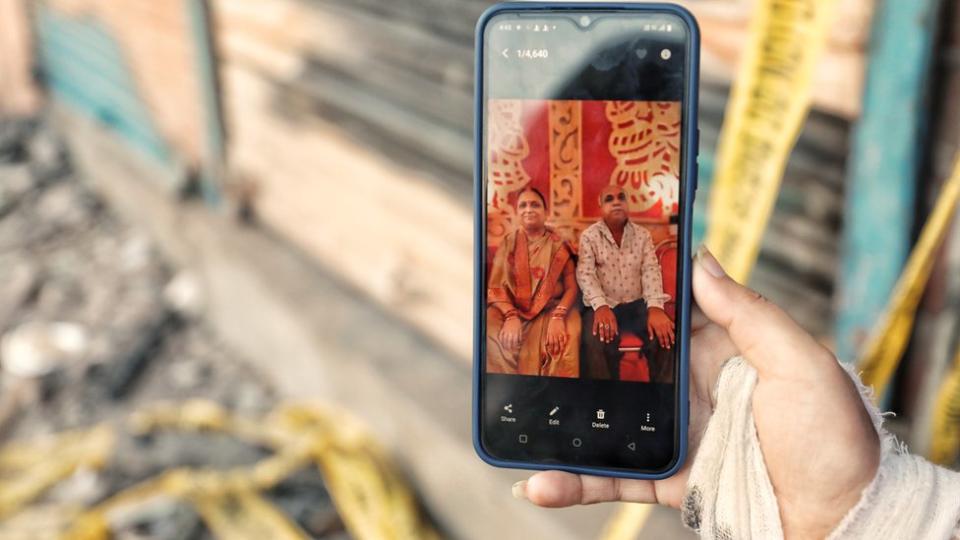 Shivani shows a photograph of her parents Rajendra Kumar and Shobha Devi on her mobile phone