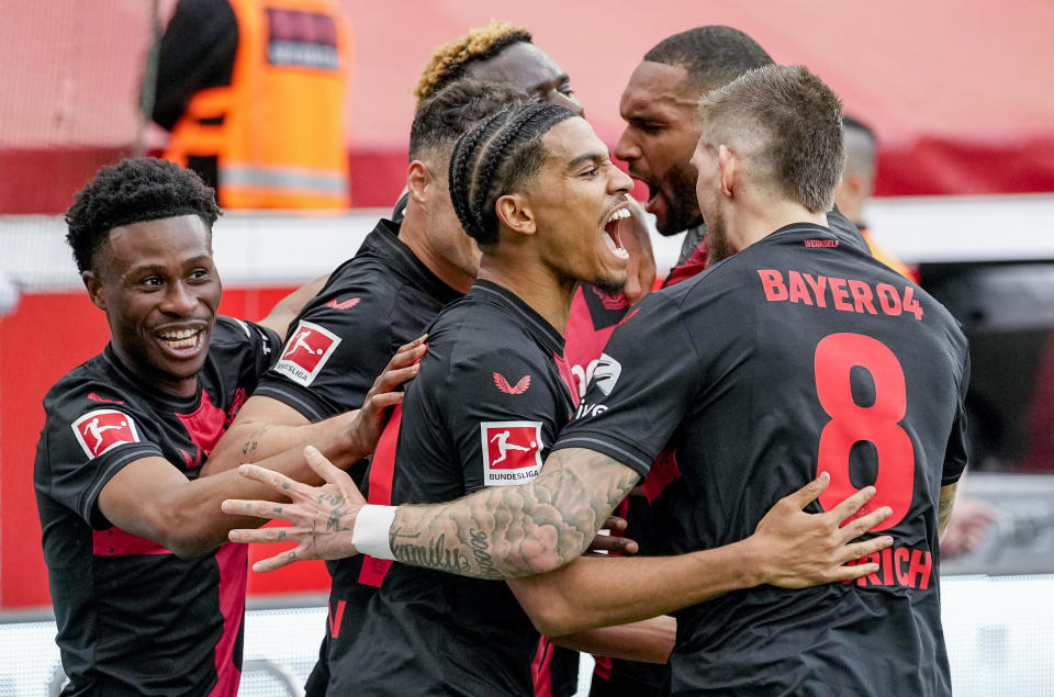 Leverkusen players celebrate their side's opening goal during a German Bundesliga soccer match between Bayer Leverkusen and Werder Bremen in Leverkusen, Germany, Sunday, April 14, 2024. (AP Photo/Martin Meissner)