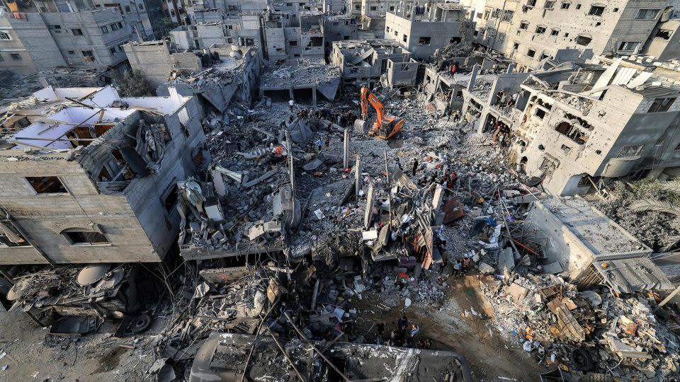 An excavator clears rubble as people search for survivors and victims' remains in Khan Younis in southern Gaza on October 25, 2023. - Mahmud Hams/AFP/Getty Images