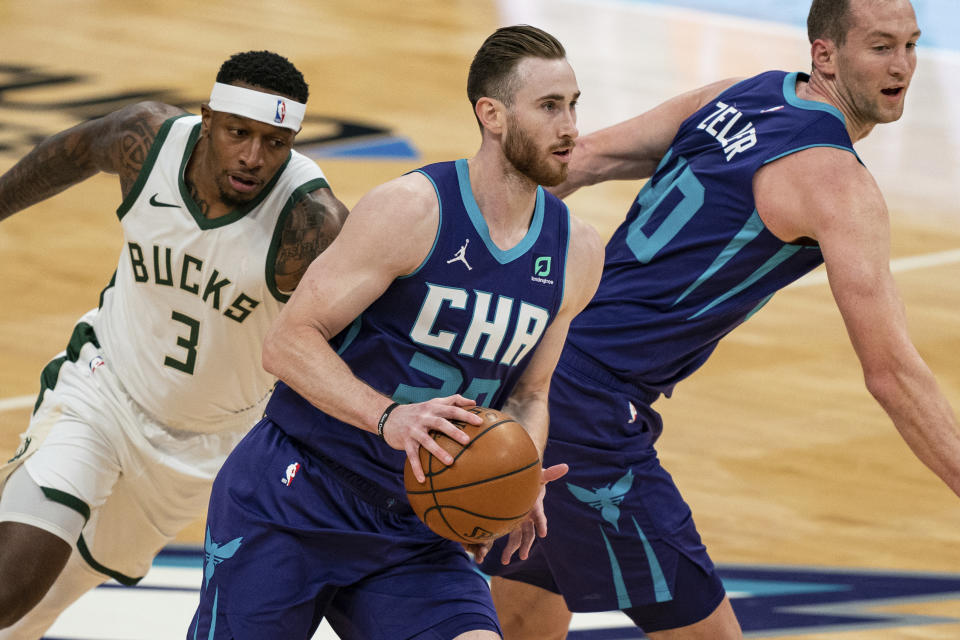 Charlotte Hornets forward Gordon Hayward (20) dribbles past Milwaukee Bucks forward Torrey Craig (3) with Hornets center Cody Zeller (40) next to him during the first half of an NBA basketball game in Charlotte, N.C., Saturday, Jan. 30, 2021. (AP Photo/Jacob Kupferman)