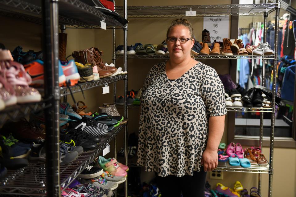 Holly Christensen stands next to the donated shoe shelves of different sizes for foster children at the Foster Network office in Sioux Falls on Tuesday, Sept. 12, 2023.