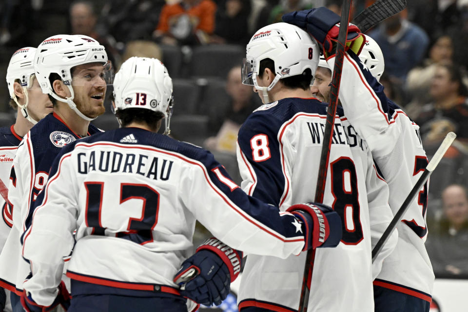 Columbus Blue Jackets center Jack Roslovic, second from left, celebrates a goal by defenseman Zach Werenski (8) with left wing Johnny Gaudreau (13) and center Boone Jenner, right, against the Anaheim Ducks during the first period of an NHL hockey game in Anaheim, Calif., Wednesday, Feb. 21, 2024. (AP Photo/Alex Gallardo)