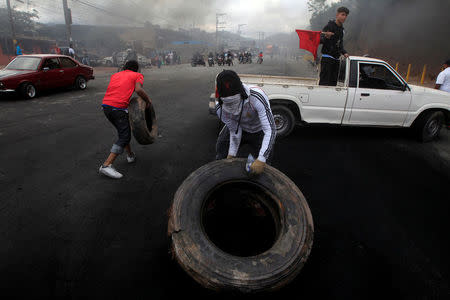 Supporters of Salvador Nasralla, presidential candidate for the Opposition Alliance Against the Dictatorship, move tires toward a barricade settled to block road during a protest caused by the delayed vote count for the presidential election in Tegucigalpa, Honduras December 1, 2017. REUTERS/Jorge Cabrera