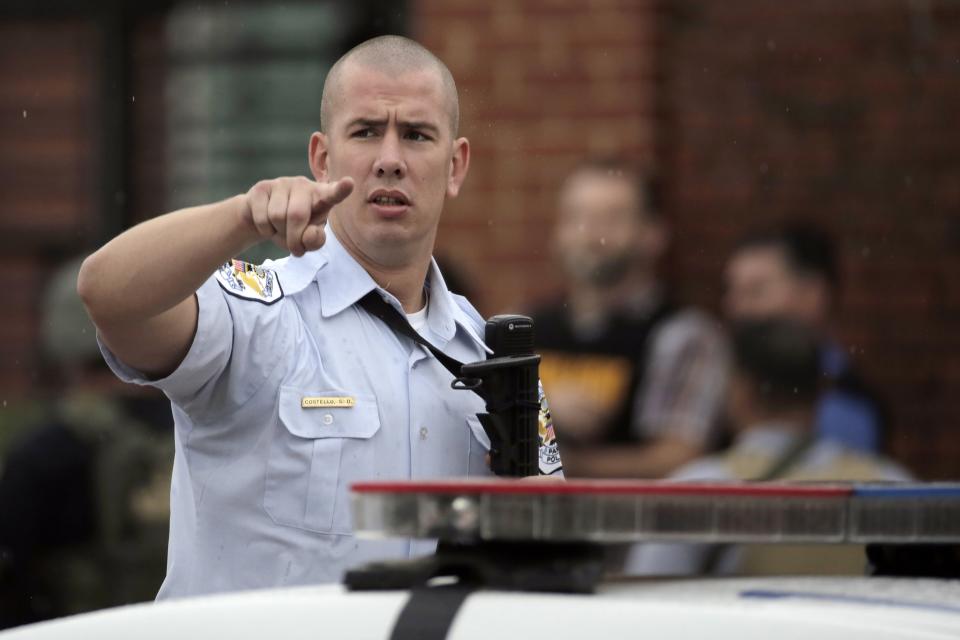 A Washington Metropolitan Police officer moves bystanders back from the scene of a shooting at the Washington Navy Yard in Washington, September 16, 2013. The U.S. Navy said several people were injured and there were possible fatalities in the shooting at the Navy Yard in Washington D.C. on Monday. The Navy did not immediately provide additional details but a Washington police spokesman said earlier that five people had been shot, including a District of Columbia police officer and one other law enforcement officer. (REUTERS/Jason Reed)