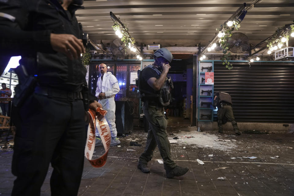 Israeli police inspect the scene of a shooting attack In Tel Aviv, Israel, Thursday, April 7, 2022. Israeli health officials say two people were killed and at least eight others wounded in a shooting in central Tel Aviv. The shooting on Thursday evening, the fourth attack in recent weeks, occurred in a crowded area with several bars and restaurants. (AP Photo/Ariel Schalit)