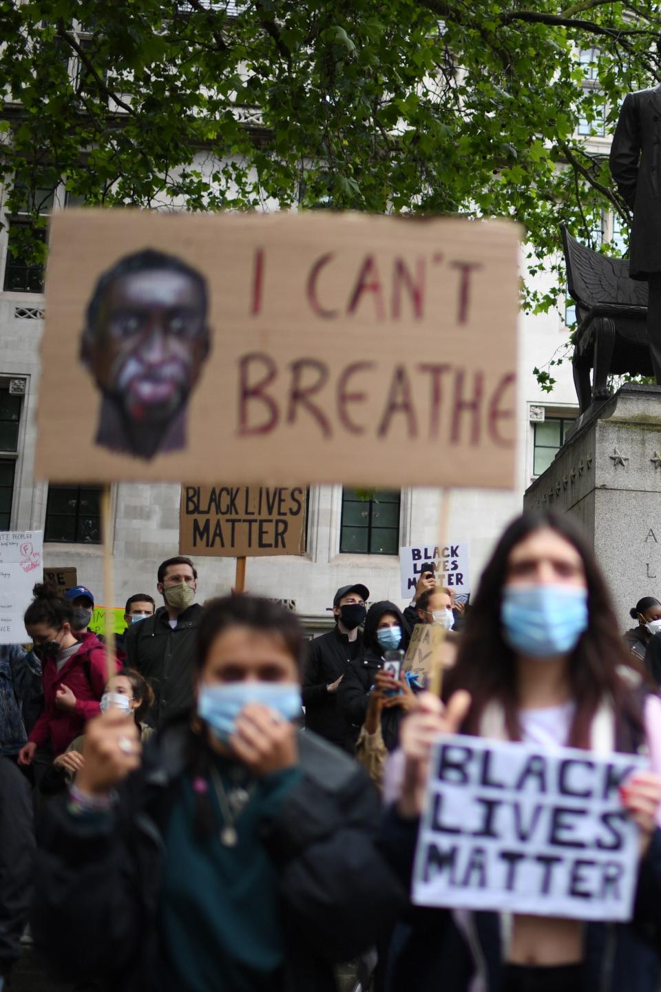 Protesters hold placards as they attend a demonstration in Parliament Square in central London on June 6, 2020, to show solidarity with the Black Lives Matter movement in the wake of the killing of George Floyd, an unarmed black man who died after a police officer knelt on his neck in Minneapolis. - Taking a knee, chanting and ignoring social distancing measures, outraged protesters from Sydney to London kicked off a weekend of global rallies Saturday against racism and police brutality. (Photo by DANIEL LEAL-OLIVAS / AFP) (Photo by DANIEL LEAL-OLIVAS/AFP via Getty Images)