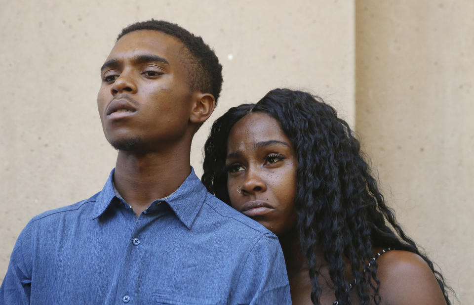 FILE - In this June 17, 2019, file photo, Dravon Ames, left, and Iesha Harper pause as they listen to a question during a news conference at City Hall in Phoenix. Ames and Harper were cursed at and threatened by Phoenix police in 2019 after their 4-year-old daughter carried a fashion doll out of a dollar store without paying for it. The couple said they were unaware that their young child took the doll. Officers aimed guns at the Black couple during the confrontation, which was captured on video cell phone. The Justice Department said Thursday, Aug. 5, 2021, it would scrutinize whether officers have used excessive force, abused the disabled and people experiencing homelessness, engaged in discriminatory policing practices and retaliated against people for activities protected by the First Amendment. (AP Photo/Ross D. Franklin, File)