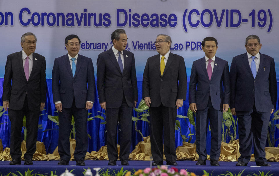 China's Foreign Minister Wang Yi, third left, stands after posing for a group photo with from left, Thailand's Foreign Minister Don Pramudwinai, Vietnamese Foreign Minister Pham Binh Minh, Philippines Foreign Affaires Secretary Teodoro Locsin Jr., Laos Foreign Minister Saleumxay Kommasith, and Brunei's Second Minister of Foreign Affairs and Trade Erywan Yusof ahead of the Special ASEAN-China Foreign Ministers' meeting on the Novel Coronavirus Pneumonia in Vientiane, Laos, Thursday, Feb. 20, 2020. (AP Photo/Sakchai Lalit)