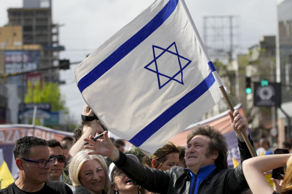 ARCHIVO - El entonces aspirante a la presidencia de Argentina Javier Milei sostiene una bandera israelí durante su acto de campaña en Lomas de Zamora, Argentina, el 16 de octubre de 2023. Antes de la victoria de Milei, cerca de 4.000 artistas e intelectuales argentinos de origen judío repudiaron entonces “el uso político” que Milei realizaba de los textos y símbolos del judaísmo. (AP Foto/Natacha Pisarenko, Archivo)