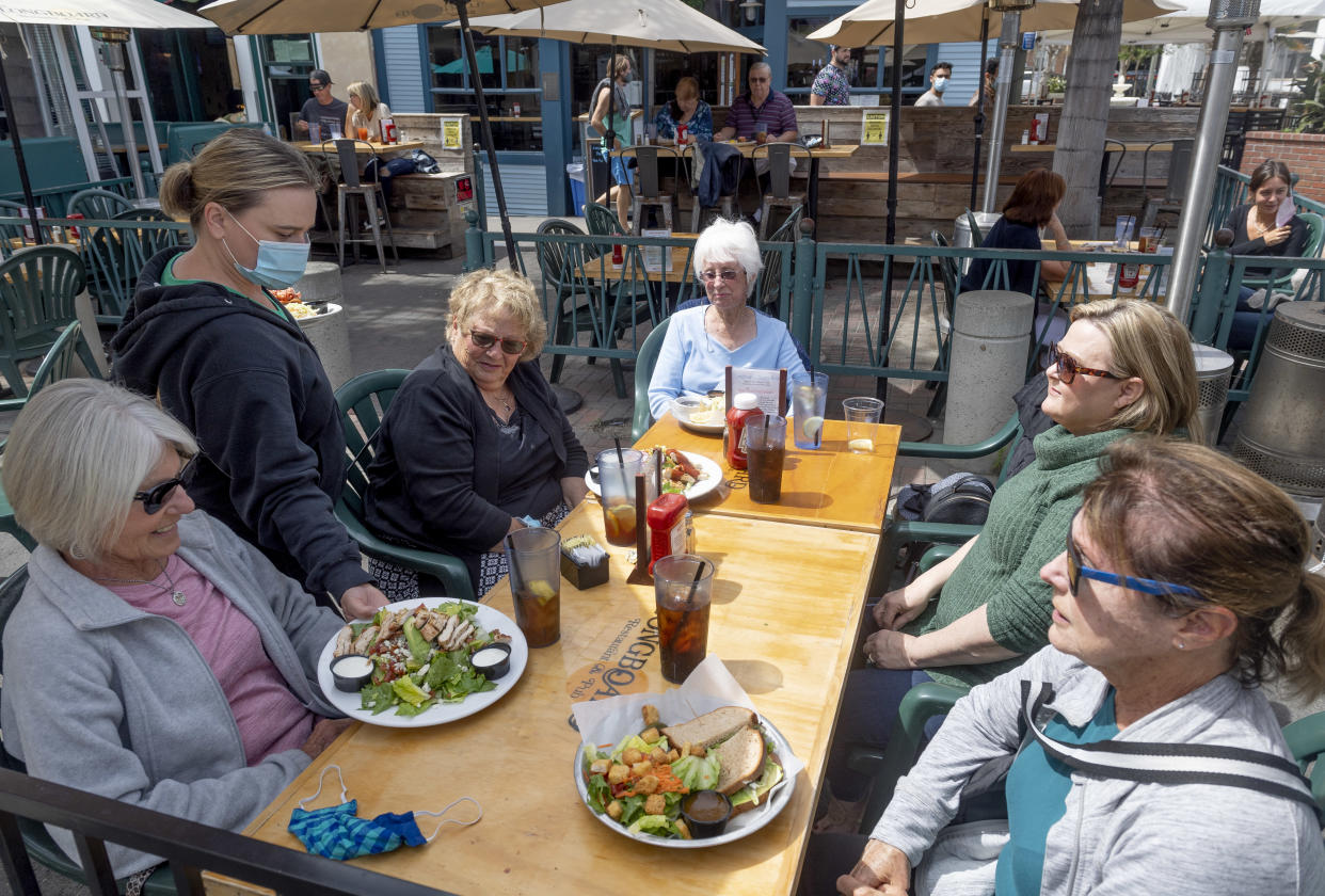 HUNTINGTON BEACH, CA - APRIL 06: Women are served lunch at The Longboard restaurant in Huntington Beach, CA on Tuesday, April 6, 2021. 