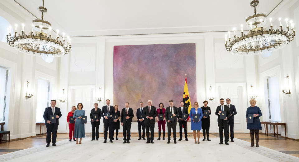 Germany's Federal President Frank-Walter Steinmeier, centre and members of the new federal government including newly elected German Chanceloor Olaf Scholz, centre left, pose for a photo at Bellevue Palace, in Berlin, Wednesday, Dec. 8, 2021. Scholz has become Germany's ninth post-World War II chancellor, opening a new era for the European Union’s most populous nation and largest economy after Angela Merkel’s 16-year tenure. Scholz’s government takes office with high hopes of modernizing Germany and combating climate change but faces the immediate challenge of handling the country’s toughest phase yet of the coronavirus pandemic. (Bernd Von Jutrczenka/dpa via AP)