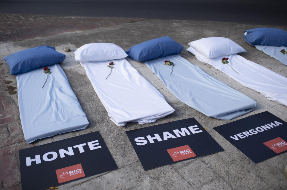 Mattresses with roses and signs that read "Shame," symbolizing COVID-19 victims lay on a sidewalk during a protest against the Government's handling of the COVID-19 pandemic, organized by the Rio de Paz NGO, in front of the Ronaldo Gazolla hospital in Rio de Janeiro, Brazil, Wednesday, March 24, 2021. (AP Photo/Silvia Izquierdo)