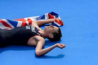 Britain's Alistair Brownlee lays exhausted with the Union flag after winning the men's triathlon event at the London 2012 Olympic Games on August 7, 2012 in London