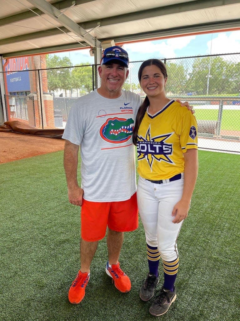 Kaylee Goodpaster takes a picture with University of Florida softball coach Tim Walton during a softball camp earlier this summer.